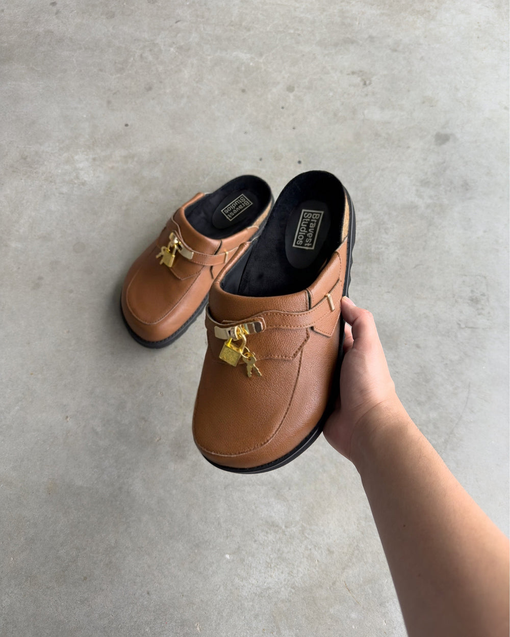 Bravest Studios Bag Clogs in light brown cognac, in hand