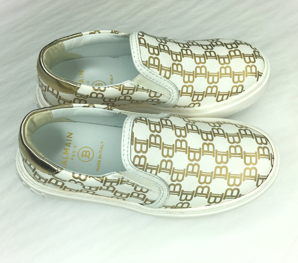 Balmain Kids Monogram All-Over Print Slip-On Trainers in white with gold – view 1 of 3