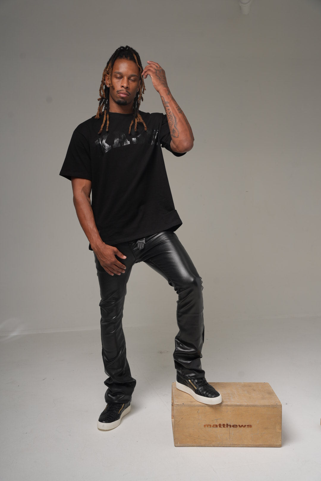Kash vegan leather stacked pants in black on model, front