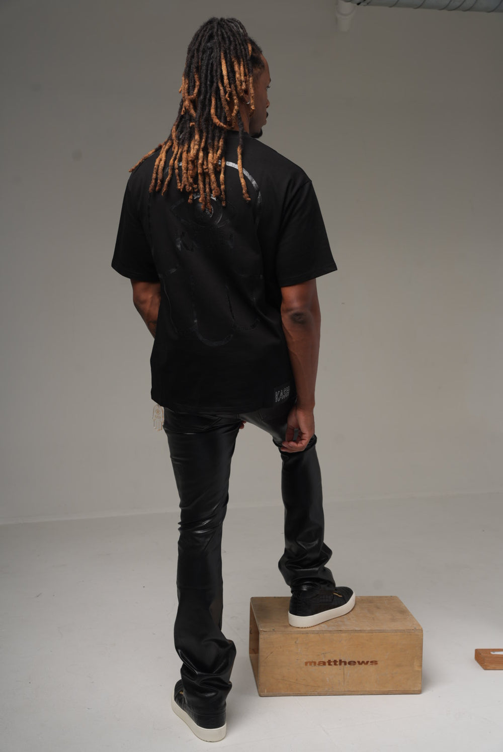 Kash vegan leather stacked pants in black on model, back
