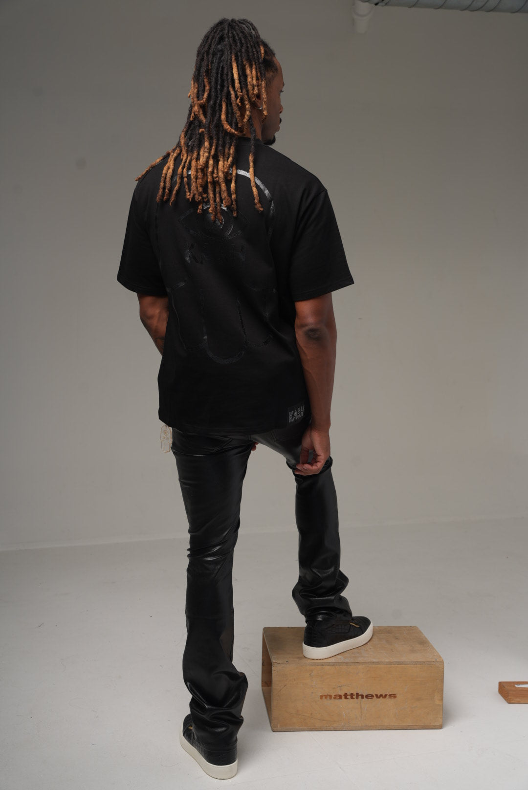 Kash vegan leather stacked pants in black on model, back