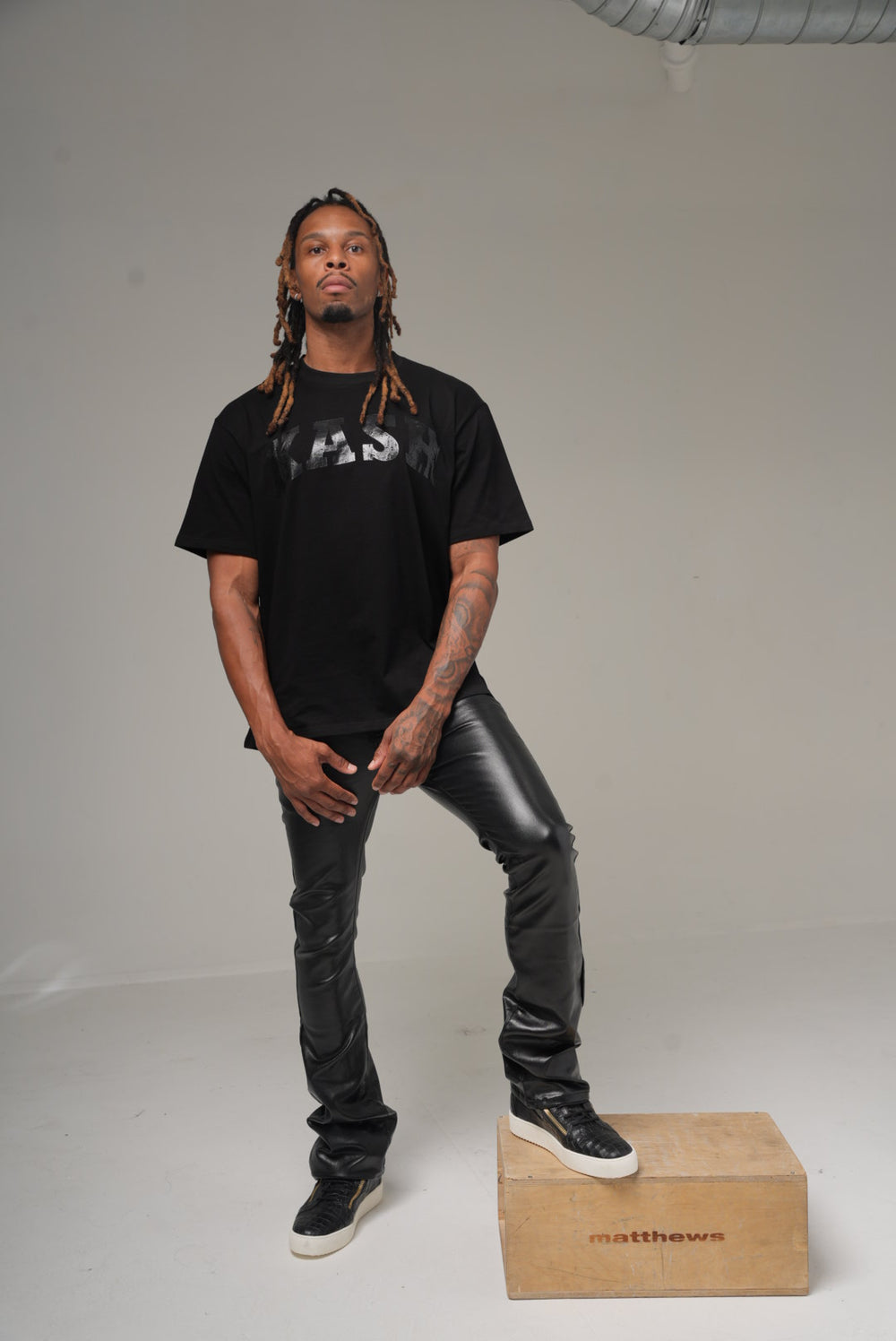 Kash vegan leather stacked pants in black on model, front